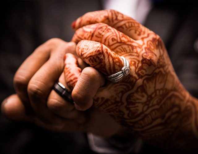 Hands with henna and wedding rings