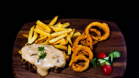 A steak platter with chips and onion rings