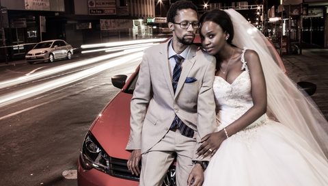 A bride and groom on a city street at night